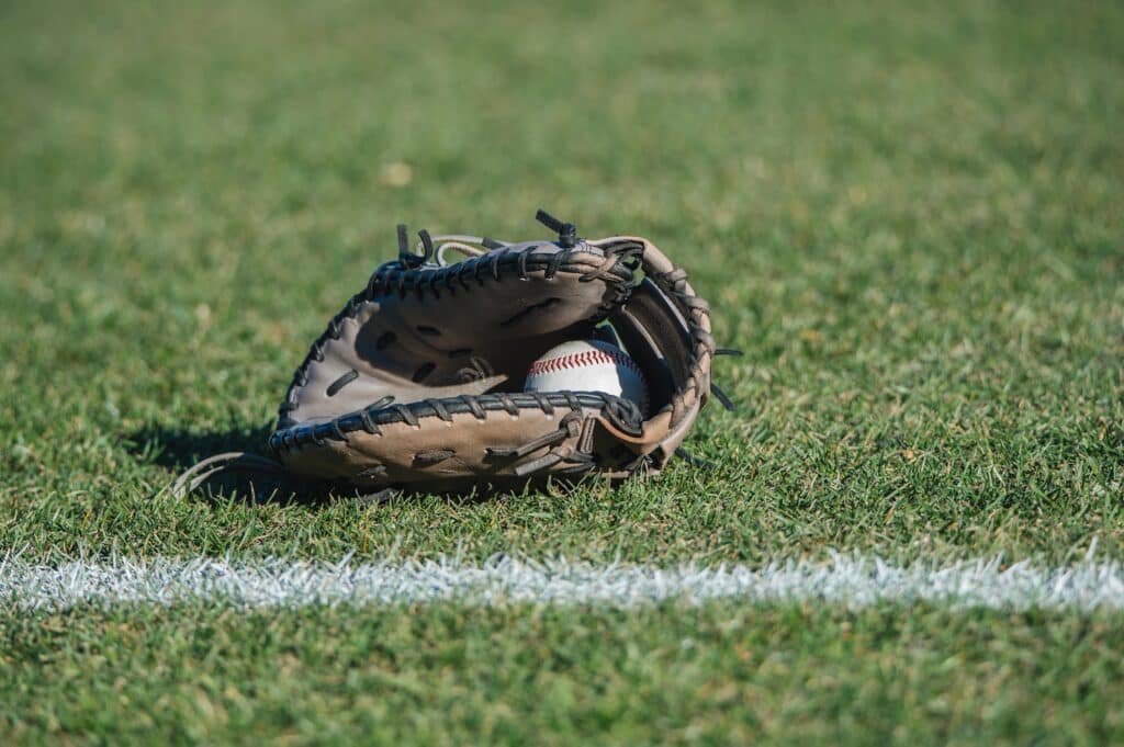 close up of baseball in baseball gloves on field